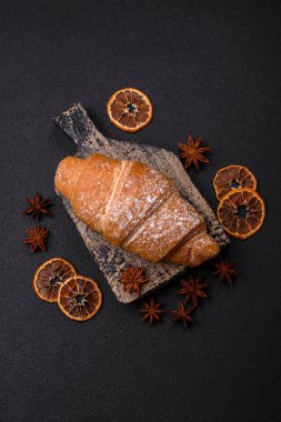 Lezzetli çıtır kruvasan, koyu beton arka planda çikolata dolgulu.