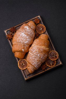 Lezzetli çıtır kruvasan, koyu beton arka planda çikolata dolgulu.