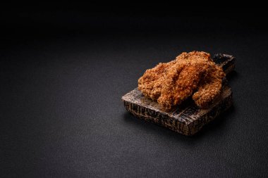 Delicious fresh crispy chicken nuggets on a dark concrete background. Unhealthy food, fast food