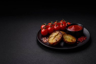 Tuz, baharat ve otlarla kızartılmış, koyu beton bir arka planda lezzetli yarım patatesler.