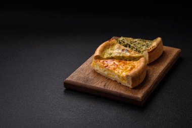 Brokoli, tavuk ya da somon peynirli lezzetli kiş. Koyu beton bir arka planda tuz ve baharatla.