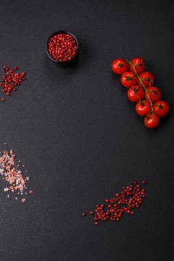 Siyah arka plan, kiraz domatesli, tuzlu, baharatlı ve otlu fotokopi alanı. Yemek malzemeleri.