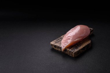 Koyu beton bir masada baharat ve otlarla taze tavuk filetosu. Et yemekleri için hazırlık.