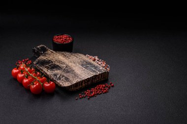 Siyah arka plan, kiraz domatesli, tuzlu, baharatlı ve otlu fotokopi alanı. Yemek malzemeleri.