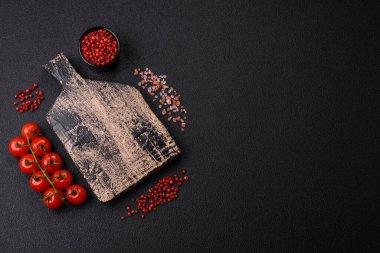 Siyah arka plan, kiraz domatesli, tuzlu, baharatlı ve otlu fotokopi alanı. Yemek malzemeleri.
