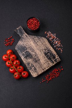 Siyah arka plan, kiraz domatesli, tuzlu, baharatlı ve otlu fotokopi alanı. Yemek malzemeleri.