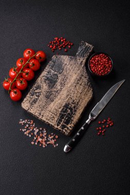 Siyah arka plan, kiraz domatesli, tuzlu, baharatlı ve otlu fotokopi alanı. Yemek malzemeleri.