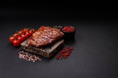 Izgarada pişmiş lezzetli ızgara pirzola, tuzlu, baharatlı ve çimento kaplı bir arka planda otlar.