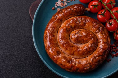 Izgarada, tuz, baharat ve otlarla pişirilmiş, koyu beton arka planda pişirilmiş nefis ev yapımı sosis.