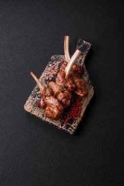 Delicious juicy meat on the bone or rack of lamb or grilled veal with salt, spices and herbs clipart