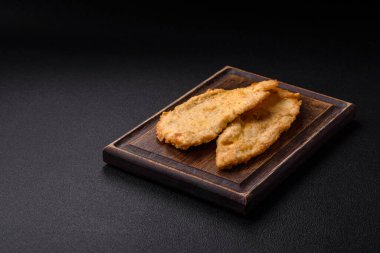 Lezzetli, sulu tavuk pirzolası, tuzlu, baharatlı ve çimento kaplı arka planda otlarla.