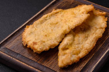 Lezzetli, sulu tavuk pirzolası, tuzlu, baharatlı ve çimento kaplı arka planda otlarla.