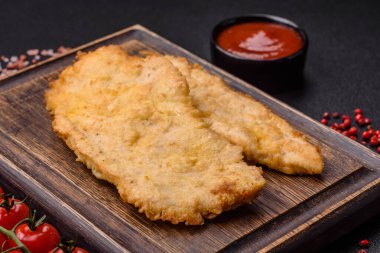 Lezzetli, sulu tavuk pirzolası, tuzlu, baharatlı ve çimento kaplı arka planda otlarla.