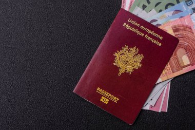 Fransa Cumhuriyeti pasaportu, uçak biletleri ve koyu beton arka planda para. Turizm ve seyahat teması üzerine kavramsal arka plan