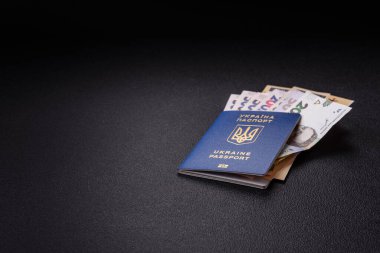 Biyometrik Ukrayna pasaportu, uçuş biletleri ve para koyu beton arka planda. Turizm ve seyahat teması üzerine kavramsal arka plan