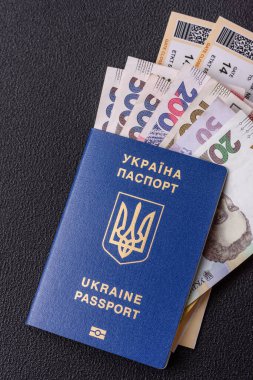 Biyometrik Ukrayna pasaportu, uçuş biletleri ve para koyu beton arka planda. Turizm ve seyahat teması üzerine kavramsal arka plan