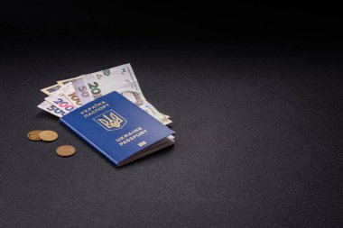 Biyometrik Ukrayna pasaportu, uçuş biletleri ve para koyu beton arka planda. Turizm ve seyahat teması üzerine kavramsal arka plan
