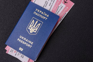 Biyometrik Ukrayna pasaportu, uçuş biletleri ve para koyu beton arka planda. Turizm ve seyahat teması üzerine kavramsal arka plan