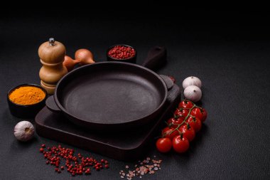 Empty ceramic round plate on dark textured concrete background. Cutlery, preparation for dinner