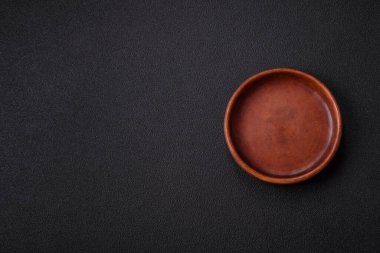 Empty ceramic round plate on dark textured concrete background. Cutlery, preparation for dinner