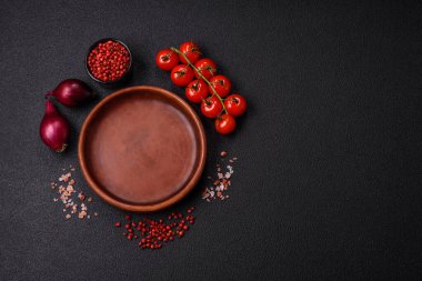 Empty ceramic round plate on dark textured concrete background. Cutlery, preparation for dinner
