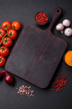 Koyu beton arka planda ev biberi, tuz, baharat ve bitkiler pişirmek için gerekli malzemeler