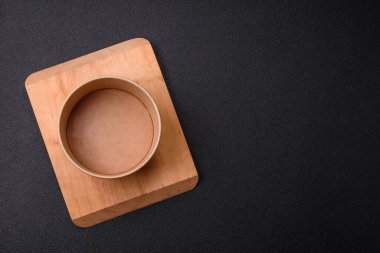 Empty ceramic round plate on dark textured concrete background. Cutlery, preparation for dinner