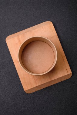 Empty ceramic round plate on dark textured concrete background. Cutlery, preparation for dinner