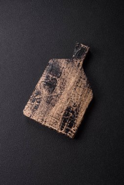 Empty wooden cutting board on dark textured concrete background. Cutlery, preparation for dinner