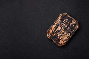 Empty wooden cutting board on dark textured concrete background. Cutlery, preparation for dinner