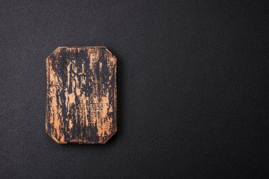 Empty wooden cutting board on dark textured concrete background. Cutlery, preparation for dinner