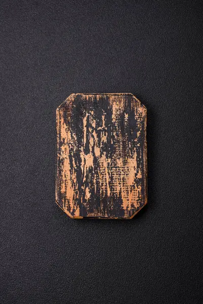 Empty wooden cutting board on dark textured concrete background. Cutlery, preparation for dinner