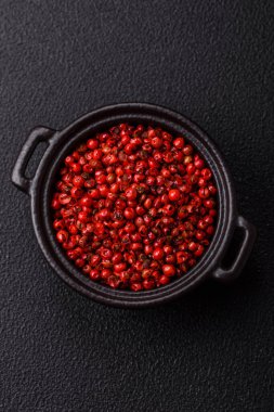 Baharat, tüm bezelyeler kırmızı ya da pembe renkli siyah beton arka planda bir kasede. Asya mutfağı