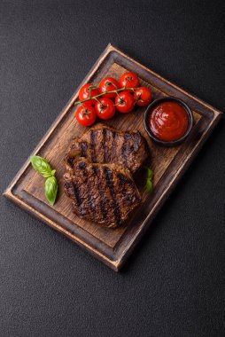 Karanlık bir arka planda taze sulu lezzetli biftek. Baharatlı ve otlu et yemeği.