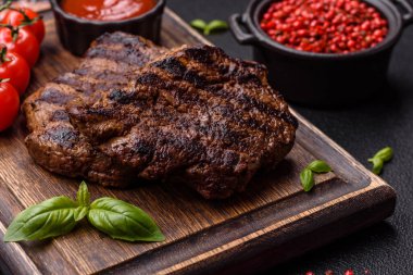 Karanlık bir arka planda taze sulu lezzetli biftek. Baharatlı ve otlu et yemeği.