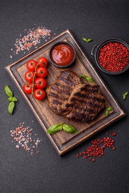 Karanlık bir arka planda taze sulu lezzetli biftek. Baharatlı ve otlu et yemeği.