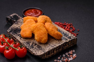 Delicious fresh crispy chicken nuggets on a dark concrete background. Unhealthy food, fast food