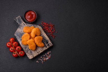 Delicious fresh crispy chicken nuggets on a dark concrete background. Unhealthy food, fast food