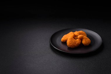 Delicious fresh crispy chicken nuggets on a dark concrete background. Unhealthy food, fast food