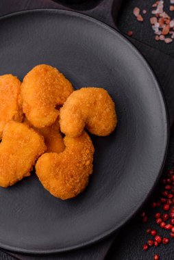 Delicious fresh crispy chicken nuggets on a dark concrete background. Unhealthy food, fast food
