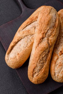 Tohumları, taneleri, tuzu ve baharatları koyu beton arka planda çıtır çıtır mini baget.