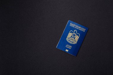Koyu beton arka planda Birleşik Arap Emirlikleri vatandaşının uluslararası pasaportu.