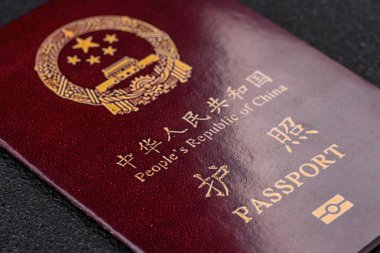Koyu beton arka planda bir Çin vatandaşının uluslararası pasaportu.