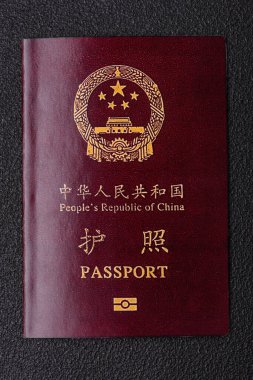 Koyu beton arka planda bir Çin vatandaşının uluslararası pasaportu.