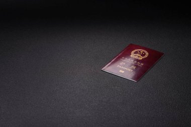 Koyu beton arka planda bir Çin vatandaşının uluslararası pasaportu.