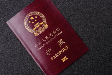 Koyu beton arka planda bir Çin vatandaşının uluslararası pasaportu.