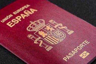Koyu beton arka planda bir İspanyol vatandaşının uluslararası pasaportu.