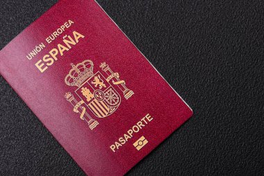 Koyu beton arka planda bir İspanyol vatandaşının uluslararası pasaportu.