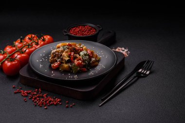 Baharatlı Asya yemeği dilimlenmiş et filetosu, acı biber, havuç ve susam tohumları koyu beton arka planda.