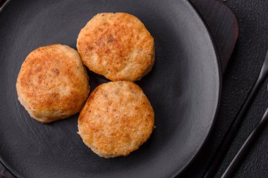 Lezzetli taze kıymalı balık pirzolası. Esmer arka planda baharatlar ve otlarla birlikte.